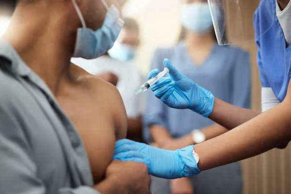 Pronti per il suo primo colpo. Una foto ritagliata di un uomo d'affari irriconoscibile che riceve la vaccinazione da un'infermiera donna in ufficio.. — Foto Stock