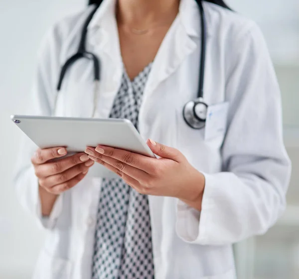 Wygodny dostęp do wszystkich rzeczy zdrowotnych. Przycięte ujęcie nierozpoznawalnego lekarza używającego tabletu cyfrowego podczas pracy w klinice. — Zdjęcie stockowe