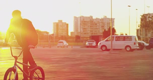 La vita è migliore su due ruote. 4k video di un giovane biker bmx fare trucchi sulla sua moto in un parcheggio urbano. — Video Stock