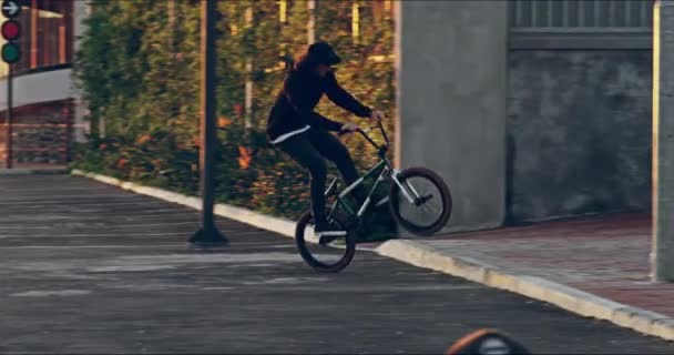 Поєднання практики та точності. 4k відео молодого байкера bmx роблять трюки на своєму велосипеді в міській обстановці . — стокове відео