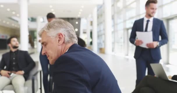 Restez toujours concentré sur votre objectif. Vidéo 4k d'un homme d'affaires mature souriant dans un bureau avec ses collègues en arrière-plan. — Video