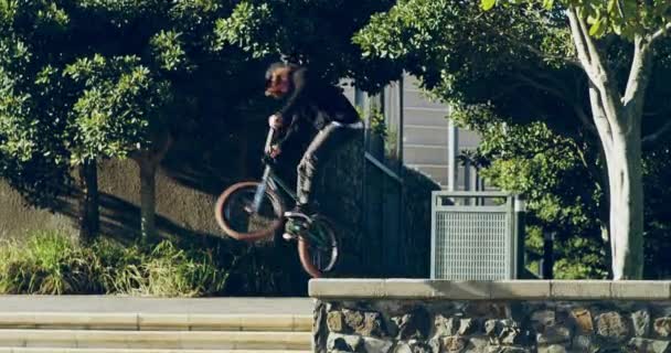 Executar uma aterragem perfeita. 4k vídeo de um jovem bmx motociclista fazendo truques em sua bicicleta em um ambiente urbano. — Vídeo de Stock