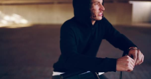 Aklı hala dublörlük yapıyor. Bisikletinin üzerinde bir köprünün altında dinlenen genç bir BMX motorcusunun 4K videosu. — Stok video