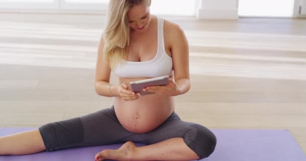 Проверьте безопасное пренатальное видео в Интернете. 4К видео беременной женщины, смотрящей видео о пренатальной йоге онлайн. — стоковое видео