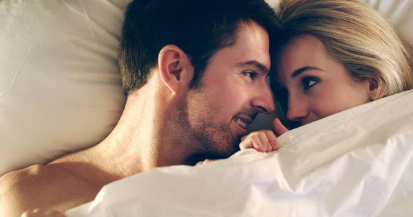 Encontrar conforto um no outro. Alto ângulo tiro de um jovem casal afetuoso deitado na cama juntos. — Fotografia de Stock