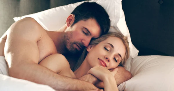 Dormea confortabil în braţe. Lovitură unghiulară mare a unui cuplu tânăr afectuos care doarme în pat împreună. — Fotografie, imagine de stoc
