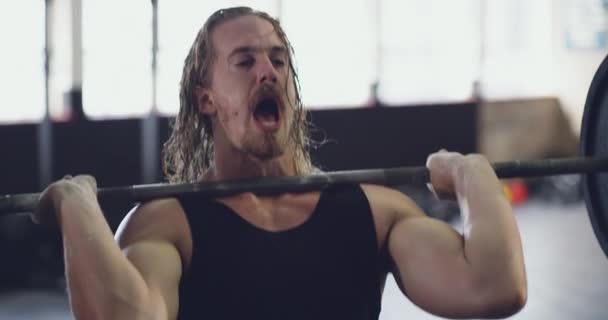 Déterminé à devenir encore plus fort. Vidéo 4k d'un jeune homme musclé pompant du fer dans la salle de gym. — Video
