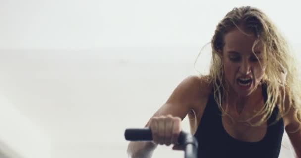 Getting the blood pumping. 4k video of an attractive young woman working out on an exercise bike in the gym. — Stock Video