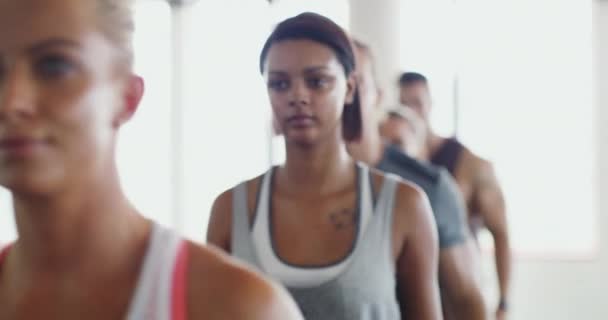 La alineación de fitness. 4k video de un grupo de jóvenes deportistas caminando en una fila en el gimnasio. — Vídeo de stock