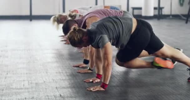 Synkroniserad lämplighet. 4k video av en grupp människor som tränar tillsammans på gymmet. — Stockvideo