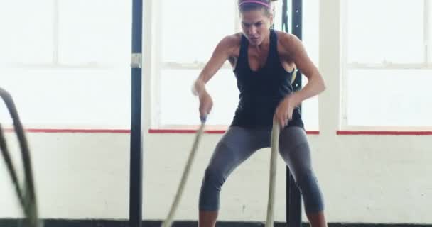 Düşündüğünden daha iyisin. Spor salonundaki ağır iplerle çalışan genç bir kadının 4K videosu.. — Stok video