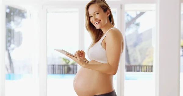 Της αρέσει να ερευνά πληροφορίες για εγκυμοσύνες. Πυροβολισμός εγκύου με τη χρήση δισκίου στο σπίτι. — Φωτογραφία Αρχείου