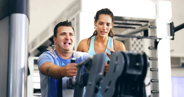 Dej mi ještě pár. Vystřižený záběr ženského fitness instruktora, který bere svého klienta přes cvičení v tělocvičně. — Stock fotografie