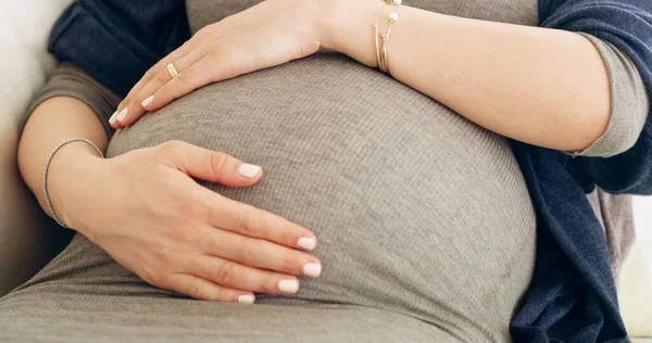 O laço da criação. Tiro de uma mulher grávida irreconhecível segurando a barriga em casa. — Fotografia de Stock