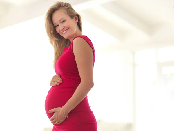 Mooie moeder te zijn. Laaghoekig portret van een mooie jonge zwangere vrouw in haar huis. — Stockfoto