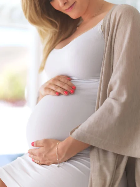 E 'gia' un genitore protettivo. Colpo ritagliato di una donna incinta irriconoscibile seduta a casa. — Foto Stock