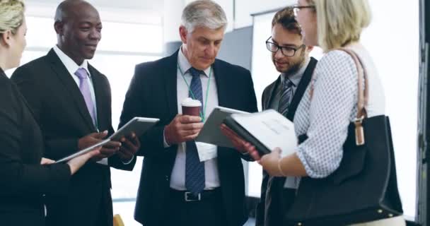 La creación de redes es un éxito con la tecnología moderna. Imágenes de video 4k de un grupo de empresarios hablando y usando tabletas digitales juntos en un centro de convenciones. — Vídeo de stock