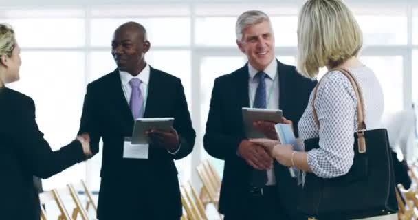 Geschäftsverbindungen knüpfen. 4k Videomaterial einer Gruppe von Geschäftsleuten, die in einem Kongresszentrum miteinander reden und digitale Tablets verwenden. — Stockvideo