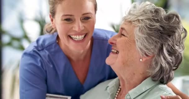 她对自己的成绩再高兴不过了。4k视频镜头：一位微笑的医生在医院里拥抱了一位老年妇女，并告诉她一些好消息. — 图库视频影像