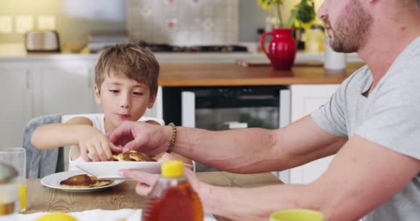 Pequeno-almoço delicioso para começar o dia. 4k vídeo de um pai e seu filho tomando café da manhã juntos em casa. — Vídeo de Stock