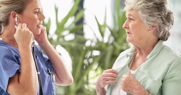 Otra revisión positiva. Imágenes de video 4k de una enfermera escuchando los latidos del corazón de un paciente mayor en un hospital. — Vídeos de Stock