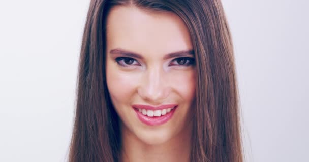 La piel preciosa y el cabello hermoso van con una sonrisa hermosa. Imágenes de video de 4k de una hermosa joven con un hermoso cabello posando en el estudio. — Vídeo de stock