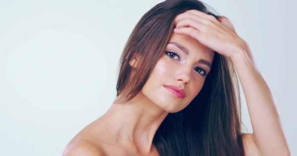 Minél ravaszabb, annál jobb. 4k videó felvétel egy gyönyörű fiatal nőről, aki megérinti a haját a stúdióban.. — Stock videók