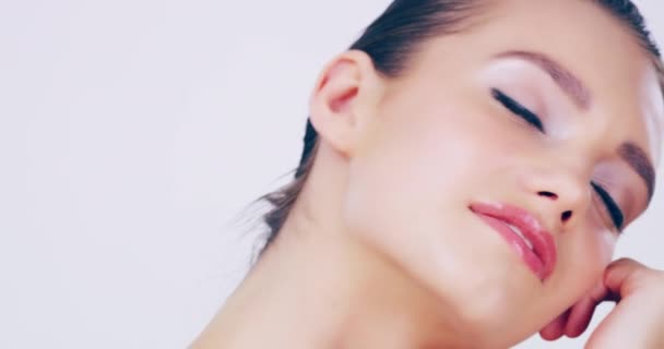 Glänsande av prakt. 4k videofilmer av en vacker ung kvinna som rör sin felfria hud i studion. — Stockvideo