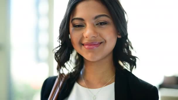 Su sonrisa dice mucho sobre ella. Imágenes de video de 4k de una atractiva joven empresaria sonriendo a la cámara en su lugar de trabajo durante el día. — Vídeo de stock