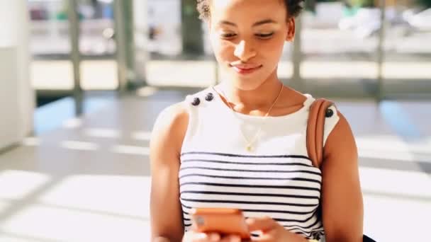 Não há como detê-la. Filmagem em vídeo 4k de uma jovem empresária atraente andando enquanto segura seu celular dentro de seu local de trabalho durante o dia. — Vídeo de Stock