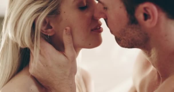 Zoveel chemie in die kus. 4K video beelden van een jong paar delen van een intieme kus thuis. — Stockvideo