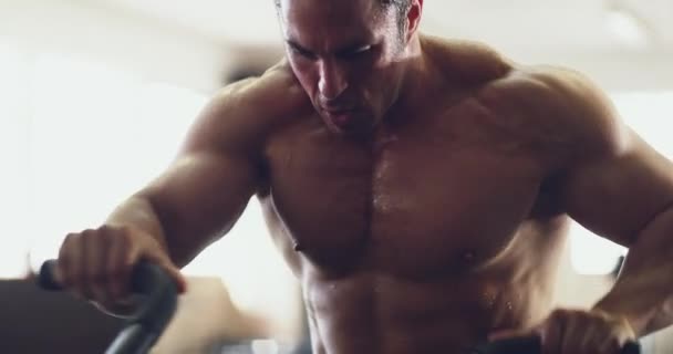A pôr esses músculos a funcionar. 4k vídeo de um jovem musculoso trabalhando em uma bicicleta de exercício no ginásio. — Vídeo de Stock