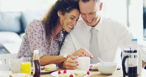 O amor excita o dia. Tiro de um casal afetuoso de meia-idade tomando café da manhã juntos na parte da manhã em casa. — Fotografia de Stock