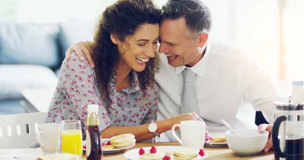 As manhãs são melhores quando os passam juntos. Tiro de um casal afetuoso de meia-idade tomando café da manhã juntos na parte da manhã em casa. — Fotografia de Stock