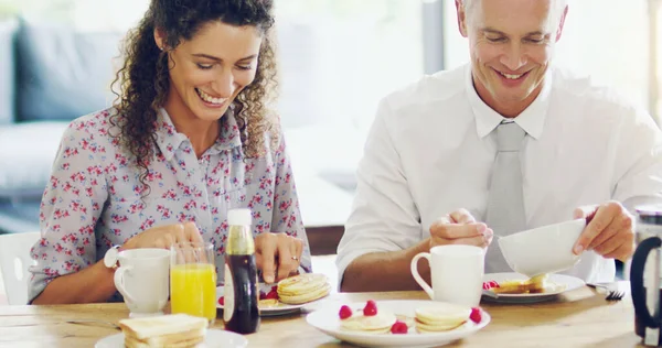 Waar geslaagde dagen worden gemaakt, aan de ontbijttafel. Shot van een gelukkig stel van middelbare leeftijd ontbijten samen in de ochtend thuis. — Stockfoto