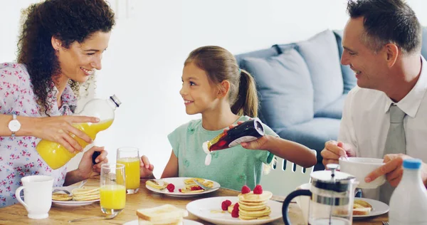 La experiencia de vinculación familiar comienza en el desayuno. Foto de una linda niña desayunando con sus padres en la mañana en casa. — Foto de Stock