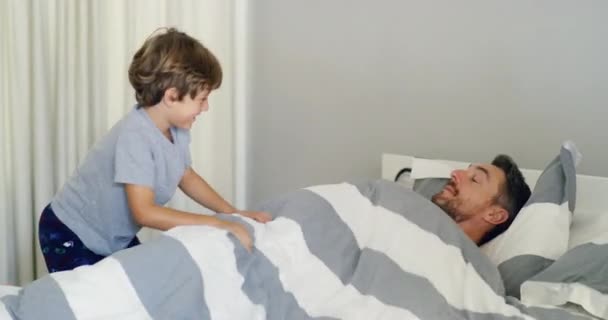 Kinek van szüksége alvásra, amikor olyan jó szórakozni. 4k videofelvétel egy apáról és fiáról, amint egy játékos pillanaton osztoznak, miután reggel felébredtek.. — Stock videók