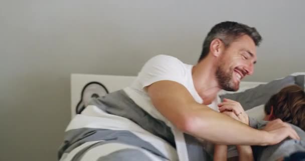 Duro y se cae al amanecer. Imágenes de video de 4k de un padre y un hijo compartiendo un momento lúdico después de despertarse por la mañana. — Vídeos de Stock