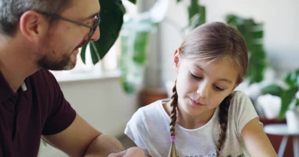 Este padre hace la nota. 4k video filmación de un padre ayudando a su hija con su tarea. — Vídeos de Stock