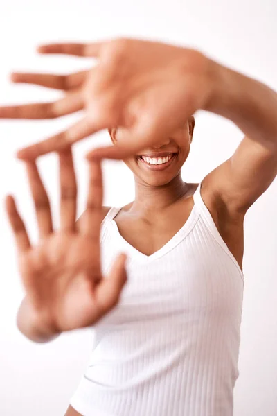 The smile is all we need to see. Studio shot of an unrecognizable woman hiding behind her hands. — Stock Photo, Image
