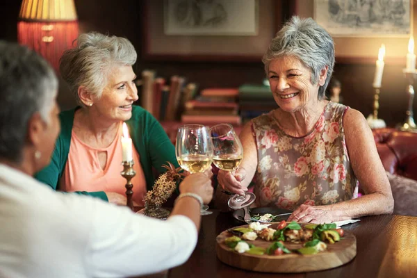 Laten we drinken op een leven van geluk. Gehakt shot van een groep van senior vrouwelijke vrienden genieten van een lunch date. — Stockfoto