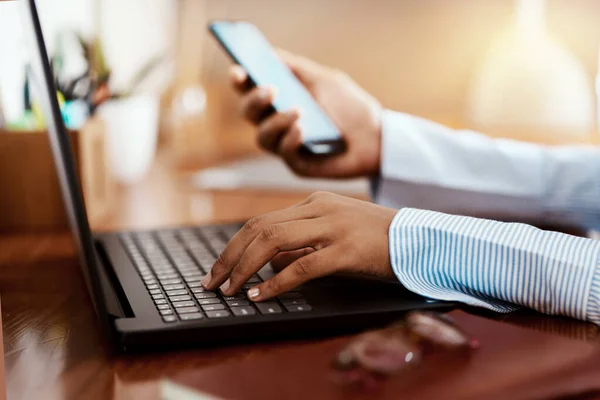 Moderne technologie geeft ons vele manieren om verbinding te maken. Gehakte foto van een zakenvrouw met behulp van een laptop en smartphone aan haar bureau. — Stockfoto