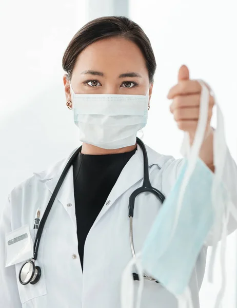 To je naše rada, jak omezit šíření koronaviru. Vystřižený snímek praktického lékaře, který drží masku. — Stock fotografie
