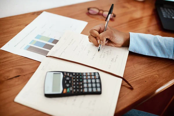 Konten führen ein ausgeglichenes Leben. Schnappschuss einer Geschäftsfrau, die an ihrem Schreibtisch Finanzdaten in ein Notizbuch schreibt. — Stockfoto