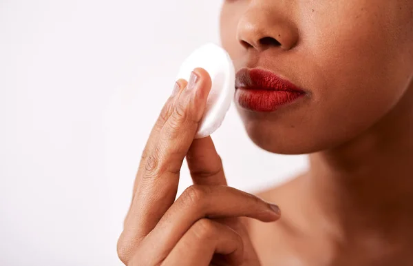 Sebuah pad kapas lembut pada kulit Anda. Gambar studio seorang wanita yang tidak dikenal menggunakan pembalut kapas untuk melepaskan lipstiknya. — Stok Foto