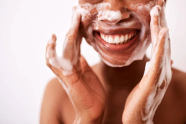 Aku mencuci muka dua kali sehari. Tembakan Studio dari seorang wanita yang tidak dikenal mencuci wajahnya terhadap latar belakang putih. — Stok Foto