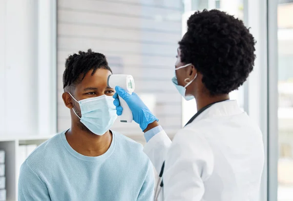 Preciso de medir a tua temperatura primeiro. Tiro de uma médica a tomar a temperatura do paciente.. — Fotografia de Stock