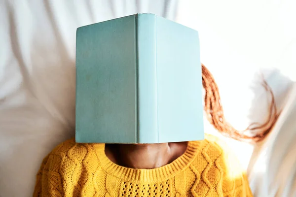 Ich habe immer meinen Kopf in den Büchern stecken. Aufnahme einer nicht wiederzuerkennenden Frau, die mit einem Buch über dem Gesicht liegt. — Stockfoto
