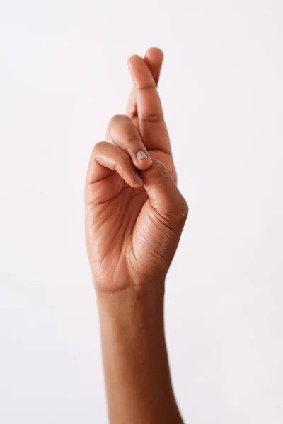 Ik hou mijn vingers gekruist. Studio shot van een onherkenbare vrouwen hand houden vingers gekruist tegen een witte achtergrond. — Stockfoto