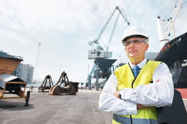 Tengo mi negocio y estoy orgulloso. Retrato de un trabajador portuario parado en el puerto en medio de la actividad de la industria naviera. — Foto de Stock